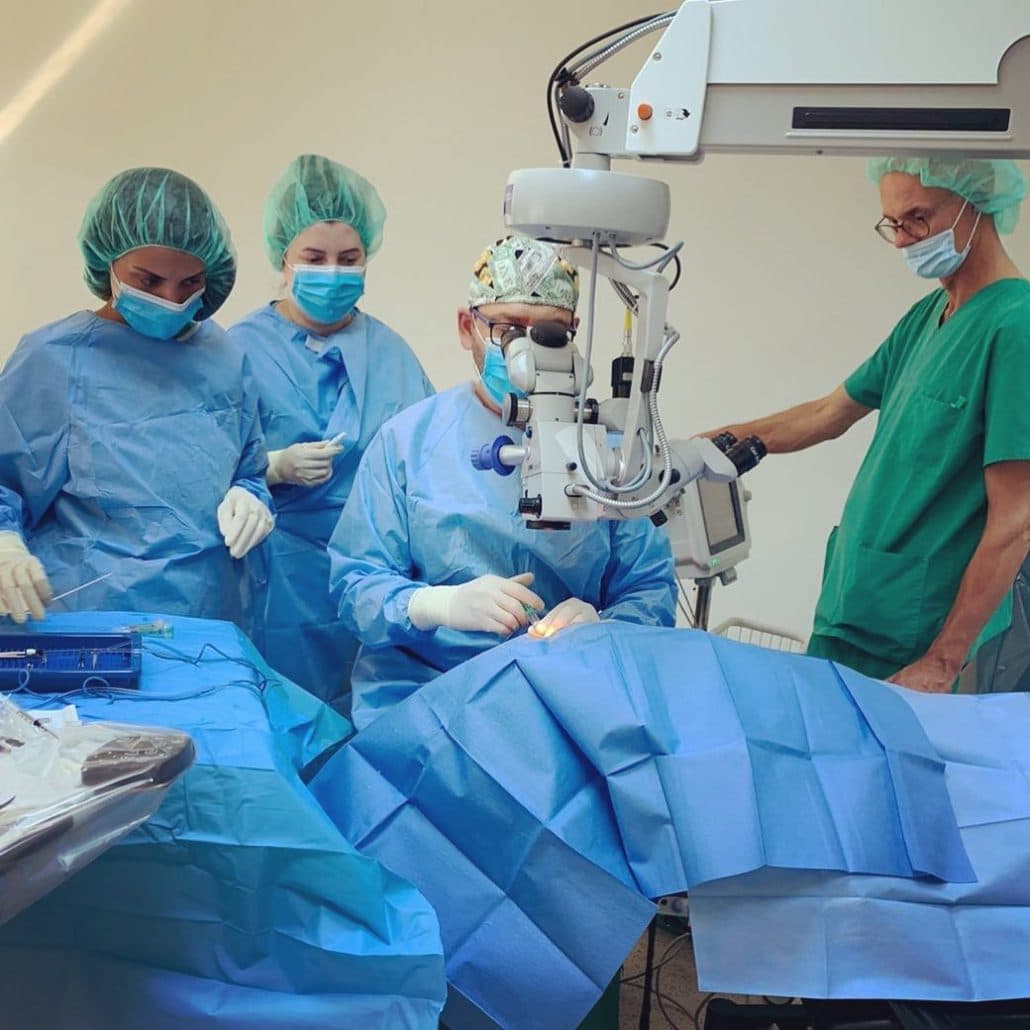 OP-Team bei einer Augenoperation am Operationsmikroskop