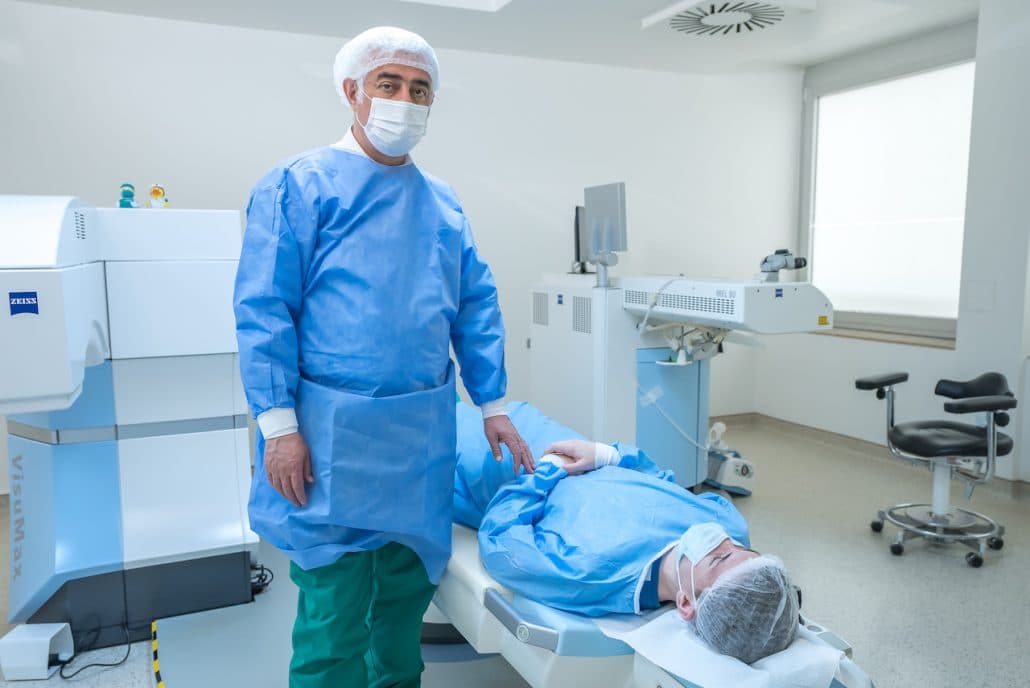 Operateur neben der Patientenliege im Laser-OP-Saal